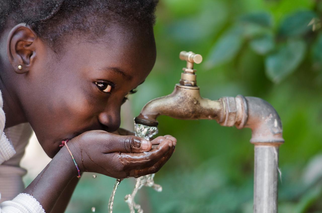 Meisje drinkt schoon water uit een kraan